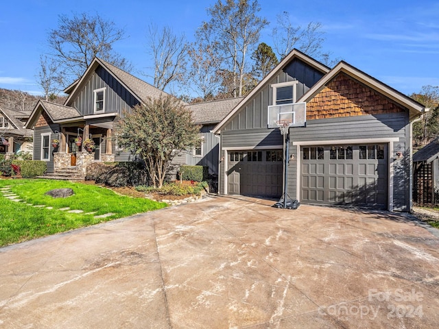 268 Firefly Cv, Lake Lure, NC 28746 - craftsman-style house with board and batten siding, driveway, a front lawn, a garage, and covered porch
