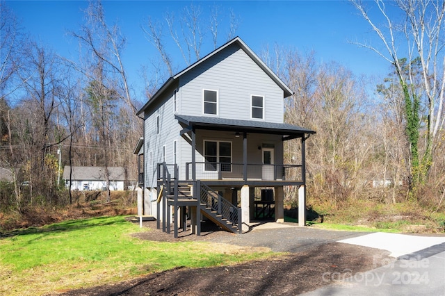 view of front of home with a front lawn, covered porch, and a carport