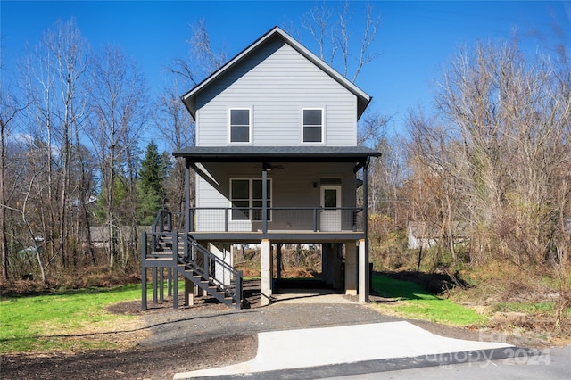 view of front of home featuring ceiling fan, a porch, and a carport