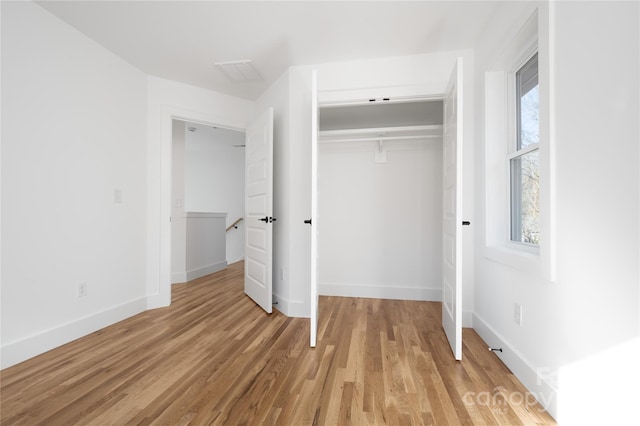 unfurnished bedroom with light hardwood / wood-style floors and a closet