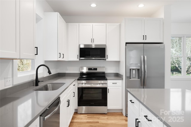 kitchen with sink, white cabinets, and appliances with stainless steel finishes