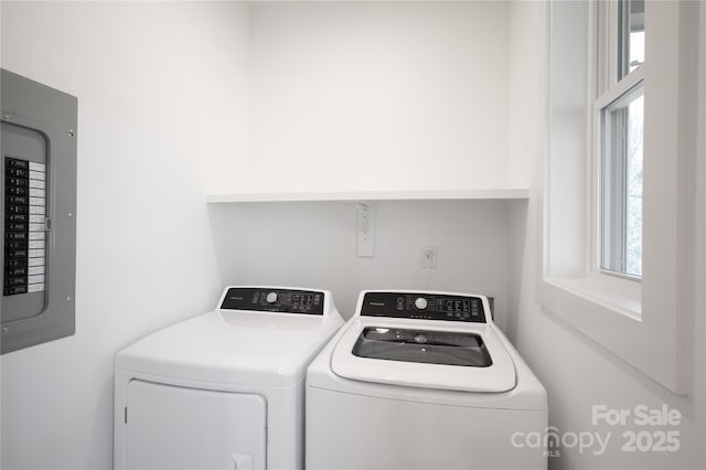 clothes washing area featuring washer and clothes dryer, a wealth of natural light, and electric panel