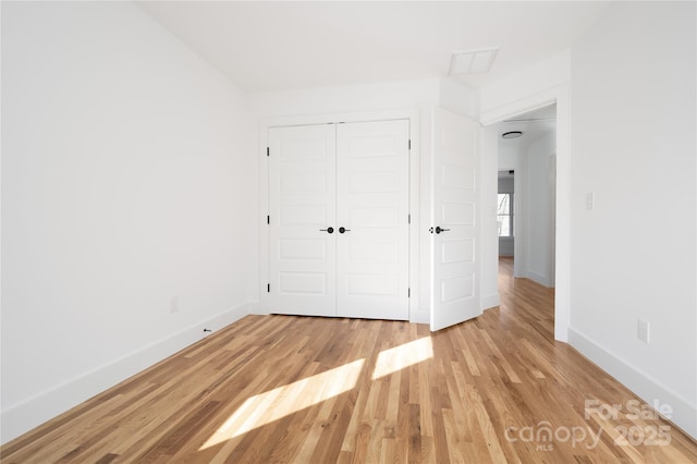 unfurnished bedroom featuring a closet and light hardwood / wood-style flooring