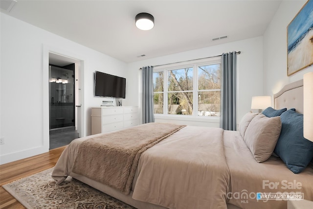 bedroom featuring hardwood / wood-style flooring and ensuite bath