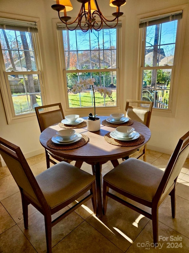 dining space with tile patterned floors and a notable chandelier