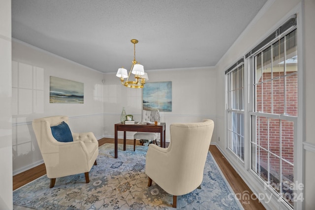 dining area featuring a textured ceiling, hardwood / wood-style flooring, crown molding, and a notable chandelier