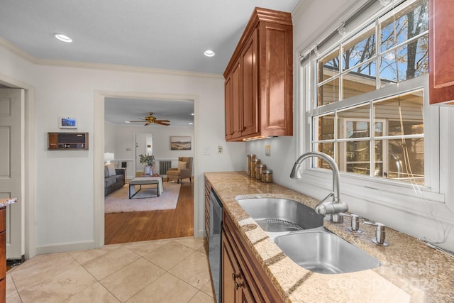 kitchen featuring light hardwood / wood-style floors, light stone counters, ornamental molding, and sink