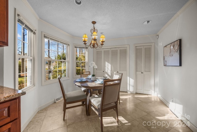 tiled dining area featuring ornamental molding, a textured ceiling, and an inviting chandelier