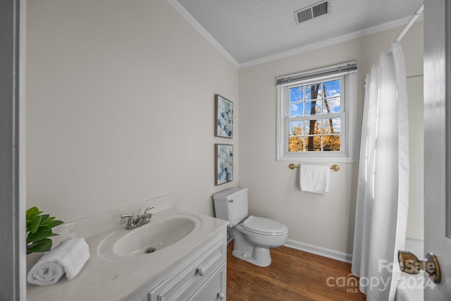 bathroom with hardwood / wood-style floors, vanity, toilet, ornamental molding, and a textured ceiling