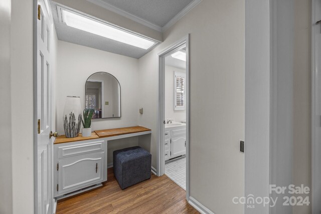 bathroom with vanity, hardwood / wood-style flooring, and crown molding