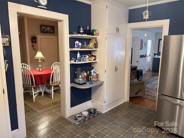 kitchen featuring crown molding and stainless steel refrigerator