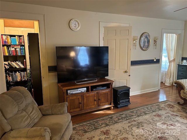 living room featuring dark hardwood / wood-style flooring and a wood stove