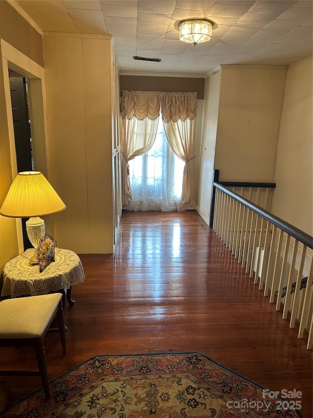 hallway featuring wood-type flooring and crown molding