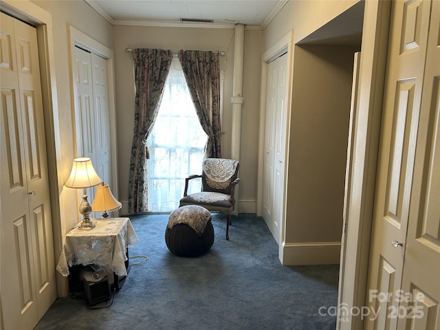 living area with dark carpet and ornamental molding