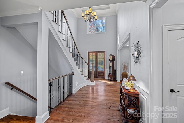 entryway featuring a notable chandelier, a healthy amount of sunlight, crown molding, and french doors