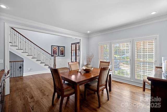 dining area featuring wood-type flooring and ornamental molding