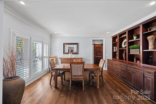 dining room featuring a barn door, crown molding, and dark wood-type flooring