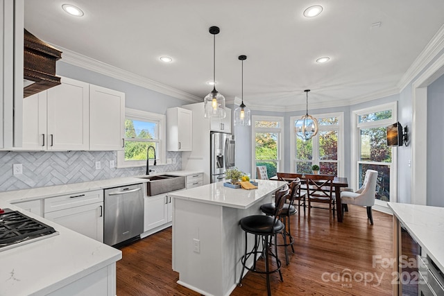 kitchen featuring white cabinetry, sink, a kitchen island, and appliances with stainless steel finishes