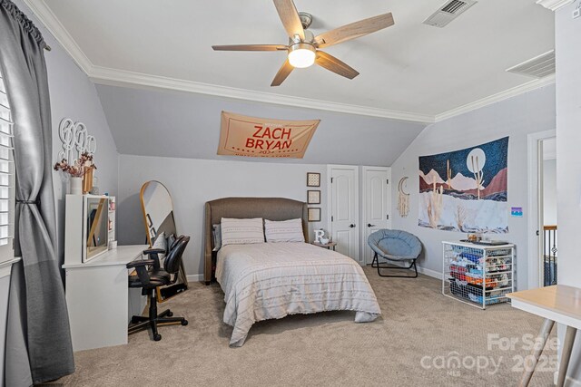 carpeted bedroom with a closet, vaulted ceiling, ceiling fan, and ornamental molding