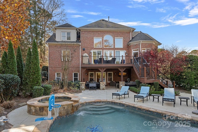 rear view of house featuring a patio area and a pool with hot tub