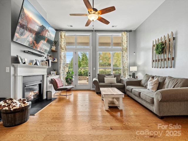 living room with ceiling fan and light wood-type flooring