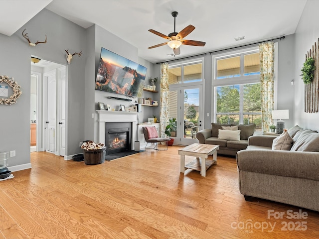 living room featuring ceiling fan, light hardwood / wood-style flooring, and french doors