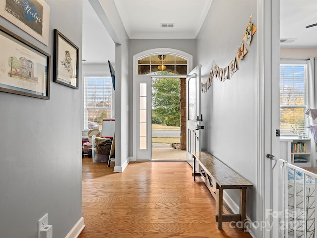 entryway featuring light hardwood / wood-style floors and crown molding