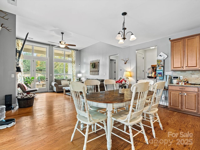 dining area featuring ceiling fan with notable chandelier and light hardwood / wood-style flooring