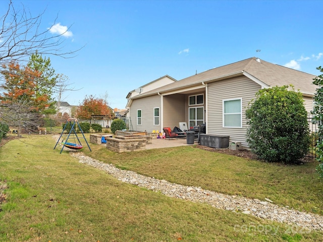 back of house featuring a yard, a patio, and an outdoor fire pit