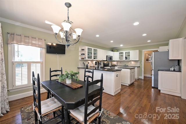 dining area featuring a chandelier, dark wood-type flooring, and ornamental molding