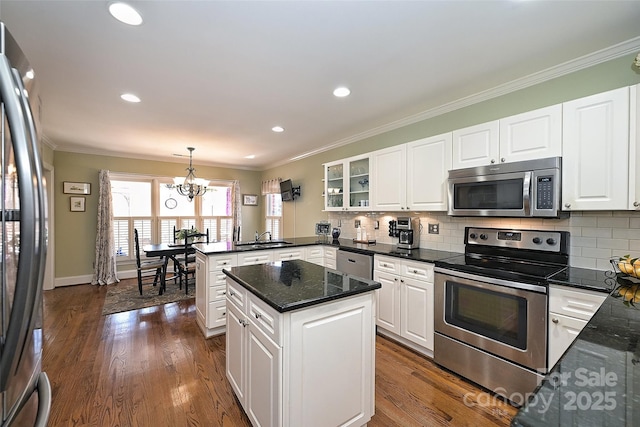 kitchen featuring pendant lighting, appliances with stainless steel finishes, white cabinetry, kitchen peninsula, and a notable chandelier