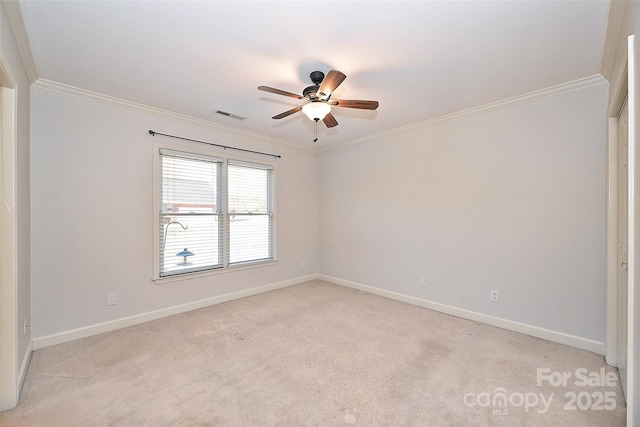 spare room featuring light carpet, ceiling fan, and crown molding