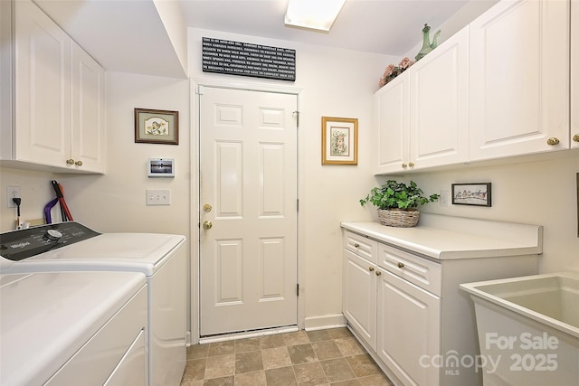 clothes washing area featuring cabinets and washer and dryer