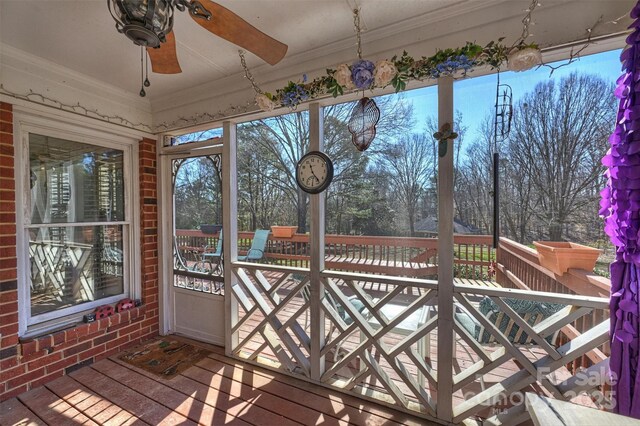 unfurnished sunroom featuring ceiling fan and a wealth of natural light