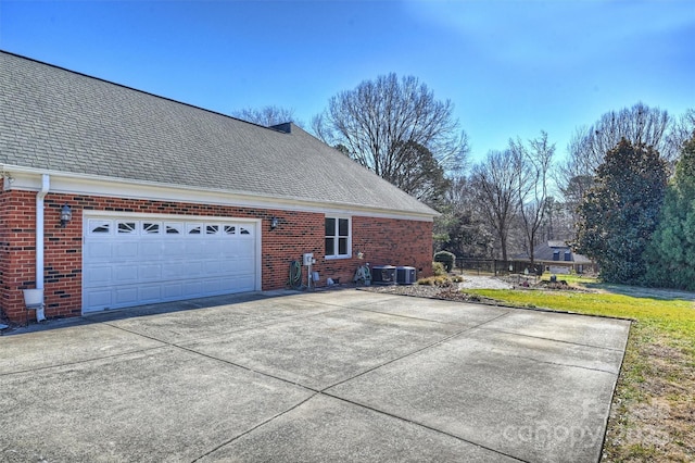 view of home's exterior with a garage, a yard, and central AC