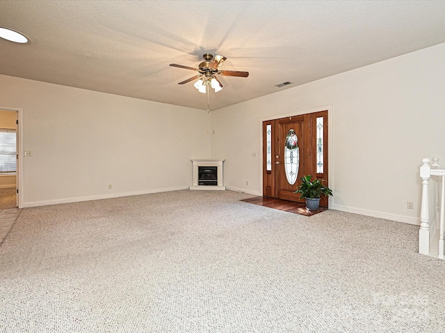 unfurnished living room with carpet flooring, plenty of natural light, and a textured ceiling