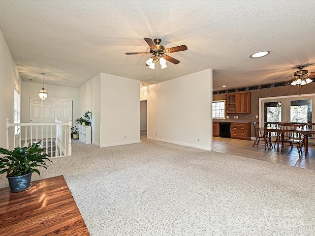 living room featuring ceiling fan, light colored carpet, and a textured ceiling