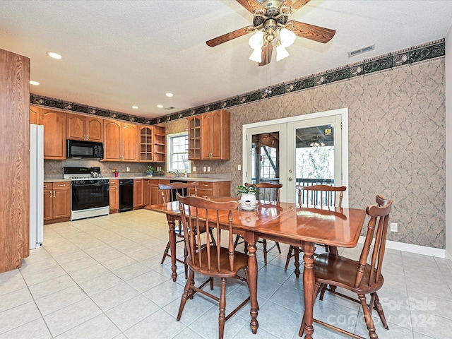 tiled dining room featuring french doors, a textured ceiling, and ceiling fan