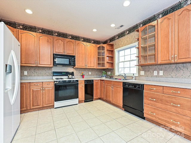 kitchen featuring sink, backsplash, a textured ceiling, light tile patterned flooring, and black appliances