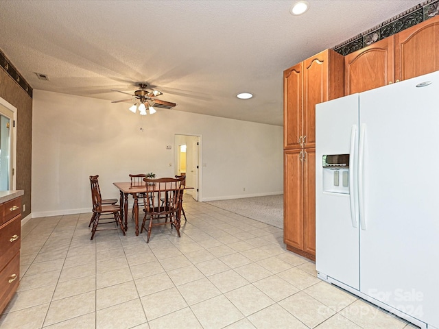 dining space featuring ceiling fan, light tile patterned floors, and a textured ceiling