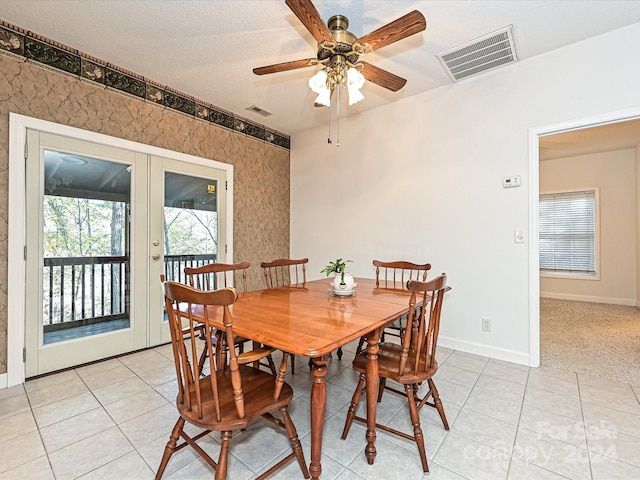 dining space with ceiling fan, french doors, light tile patterned flooring, and a textured ceiling