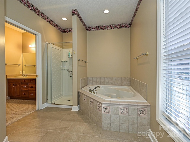 bathroom with plenty of natural light, shower with separate bathtub, a textured ceiling, and vanity