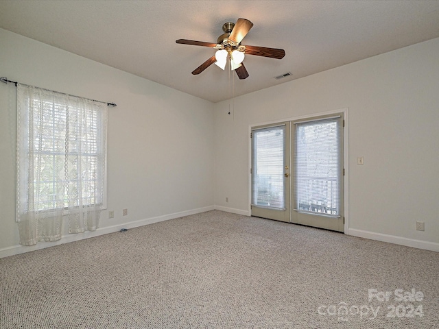 carpeted empty room with ceiling fan and french doors