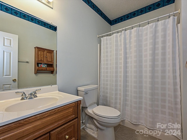 bathroom featuring tile patterned flooring, a textured ceiling, toilet, vanity, and a shower with shower curtain