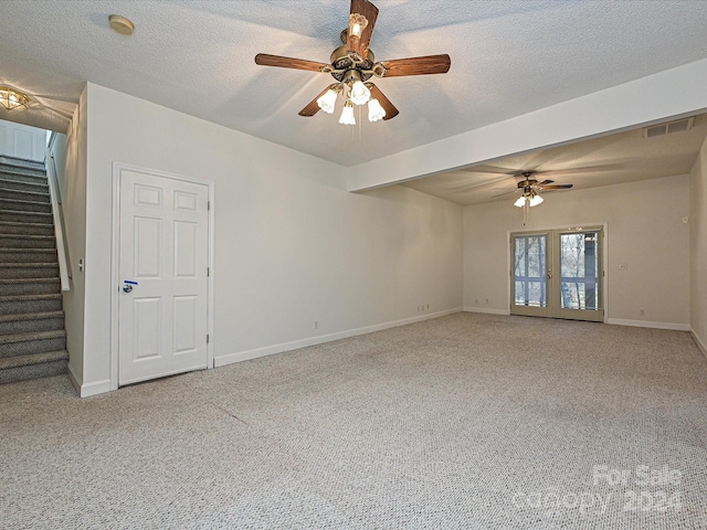 carpeted empty room featuring ceiling fan and a textured ceiling