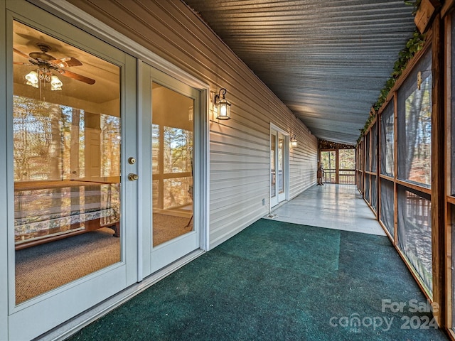 unfurnished sunroom featuring ceiling fan