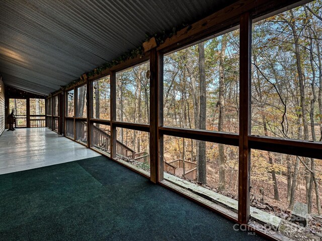 unfurnished sunroom featuring lofted ceiling and a healthy amount of sunlight