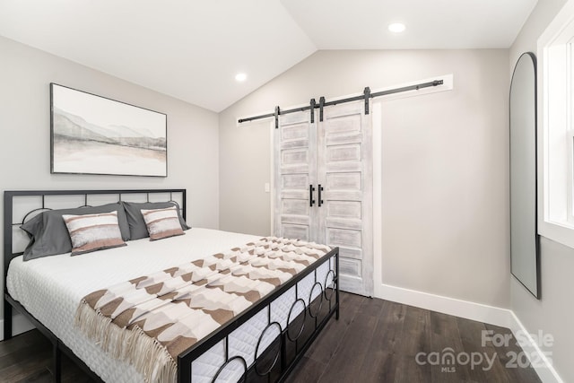 bedroom featuring a barn door, dark hardwood / wood-style floors, and lofted ceiling