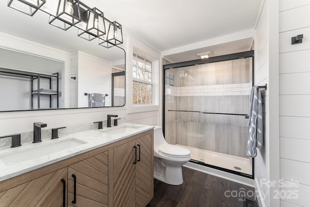 bathroom with vanity, toilet, wood-type flooring, and a shower with door