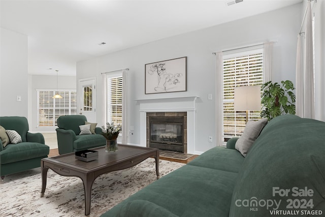 living room featuring a tile fireplace and a wealth of natural light